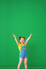 funny child with raised hands in the air. girl with a Lollipop is funny