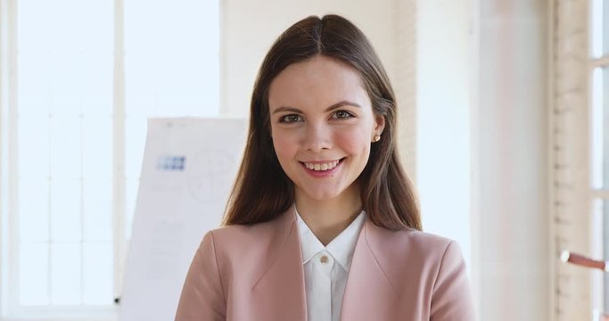 Head shot beautiful young confident business woman in formal wear looking at camera. Friendly skilled professional financial consultant, female boss executive team leader close up front portrait.