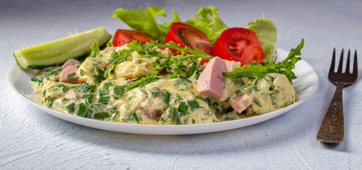 omelet on a plate with tomatoes, cucumber and lettuce