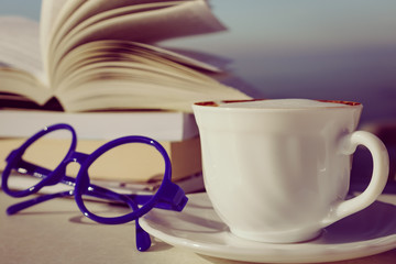 Coffee cup and books outdoors