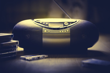 Outdated retro audio tape recorder on a dark background. Audio cassettes lie near him. Retro audio....