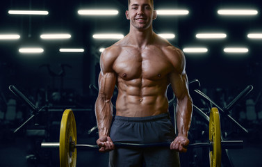 Fototapeta na wymiar Bodybuilder strong man pumping up biceps muscles