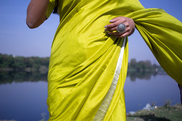 Indian girl wearing green saree standing in a landscape