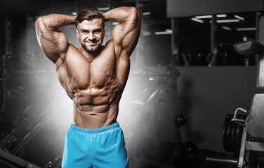 Obraz na płótnie Canvas Bodybuilder strong man pumping up abs muscles