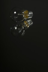 An old incandescent light bulb on black background