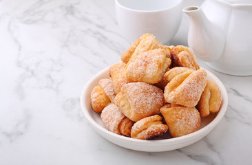 Freshly baked cottage cheese and sugar cookies (triangles, angles) in a marble background. Crow's feet.
