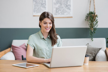 Young woman using laptop at home, girl working on computer indoor, Freelance, student lifestyle, distance education, work or studying from home, technology and online shopping concept