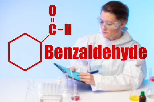 Girl chemist in the laboratory against the background of the molecular formula and the inscription Benzaldehyde. Raw materials for the production of amphetamine. Types of solvents.