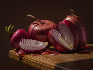 Juicy onions, on a wooden table, with a dark background, soft light. Imitation of a Dutch kitchen still life. Mono food. - 351824962