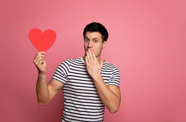 Soft heart. Close-up photo of a surprised man in a striped t-shirt, who is looking in the camera,...