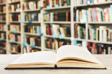 Open hardcover book on table in library