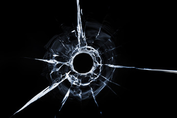 bullet hole in glass close up on black background