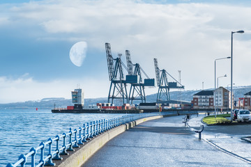 Greenock Esplanade to Ocean Terninal Docks Early Morning with Half Moon above the Cranes and Snow on the Greenock Hills