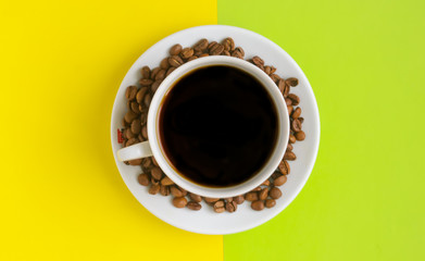 Top view, A cup of black coffee with coffee beans on yellow green background.