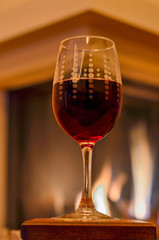 glass of red wine and the fireplace as background