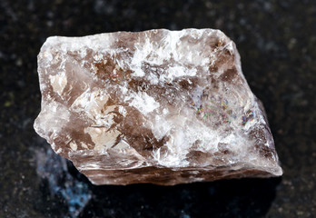 closeup of sample of natural mineral from geological collection - unpolished Smoky Quartz rock on...