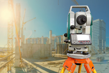 Total station. Geodetic tool at construction site. Distance measuring. Topographic equipment during construction. Concept - sale of total stations. Total Station on background of high-rise buildings