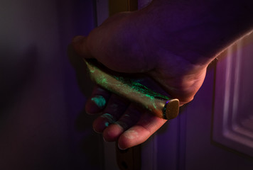Hand grabbing door handle with Uv showing the bacteria, viruses, visualisation.