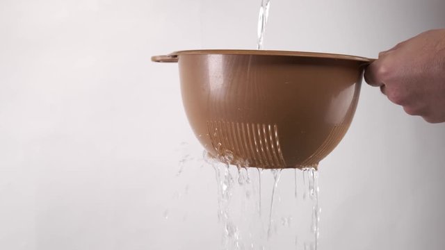 Water poured through a strainer or colander