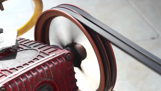 Closeup rotating pulley and belt on air pump machine