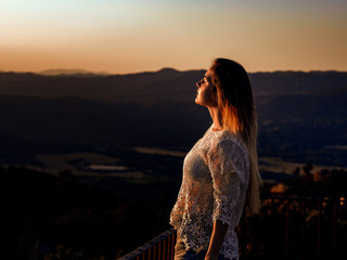 woman looking at the sun in a landscape breathing with relationship and with an orange light