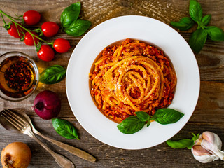 Spaghetti with tomato sauce, meat and parmesan on wooden background
