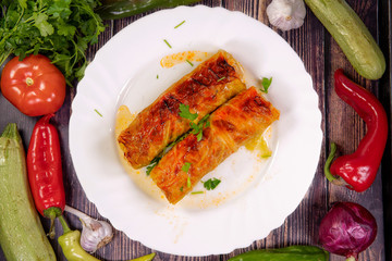 Tasty Cabbage Rolls on a white plate, on a wooden table. Top view