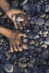 Woman hands touching stones on the beach
