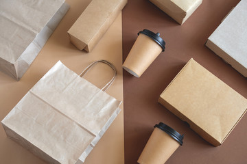 top view flat lay disposable blank delivery food packaging on a beige and brown background