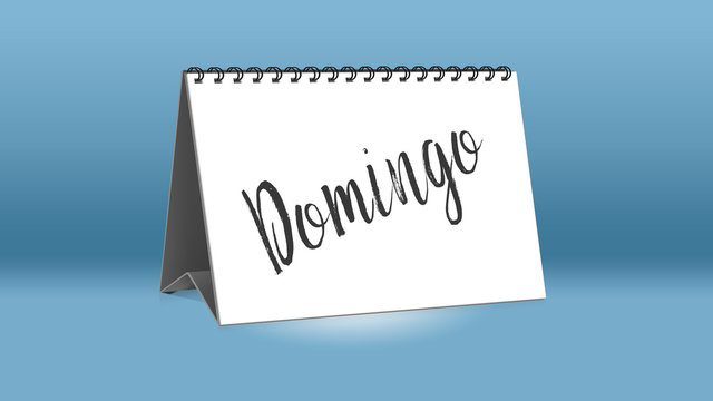 Ein Kalender für den Schreibtisch zeigt den spanischen Wochentag Domingo (Sonntag in deutscher Sprache)