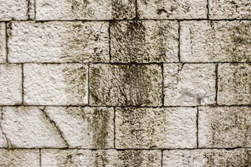 City background, white old wall made of large bricks. Close-up.