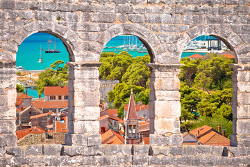Trogir old city rooftops and turquoise archipelago view through stone windows