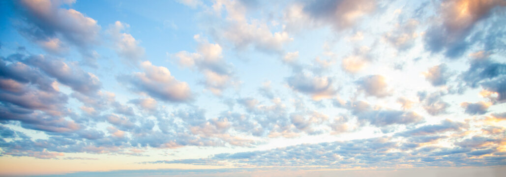 Blue sky clouds background. Beautiful landscape with clouds and orange sun on sky © millaf