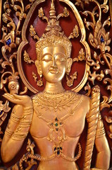 Fototapeta premium Incredible beauty at Wat Phra Singh in Chiang Rai: Image of a golden Buddha on a shutter