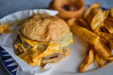 Cheeseburger with onion rings and french fries