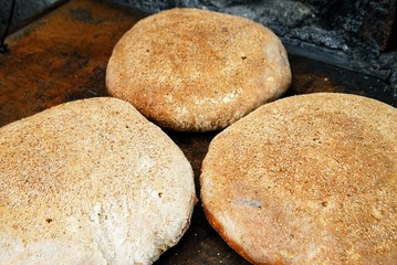 Baking special bread in traditional oven, Olympos village, Karpathos island, Greece.