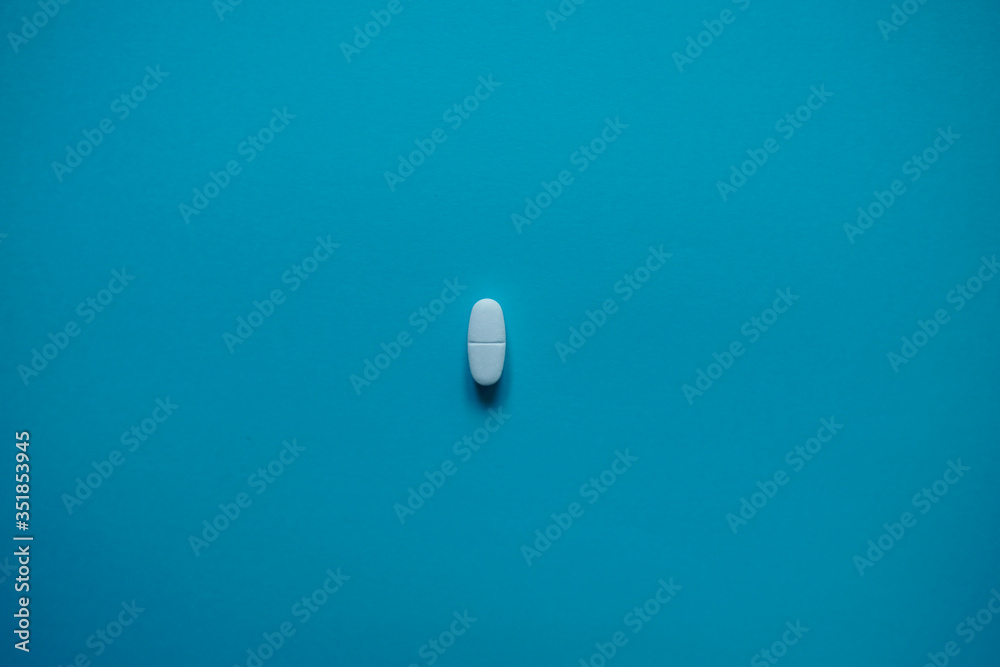 Wall mural White pills  on a paper background with a free area for text