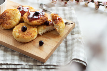 Breakfast in the morning. Cottage cheese pancakes with jam  on wooden background. Russian, Ukrainian cuisine.