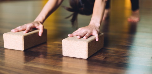 woman doing yoga exercises using bricks for yoga.