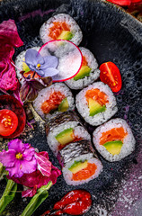 sushi roll with salmon, avocado, rice in plate