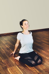 Woman sitting on the floor on her heels and with her arms back performing yoga relaxation exercises