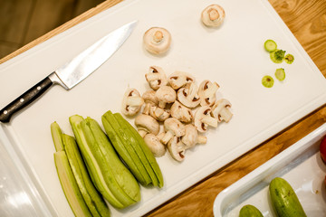 top view of board with sliced champignons and green zucchini