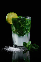 Fruit cocktail on a black background with mint and loim
