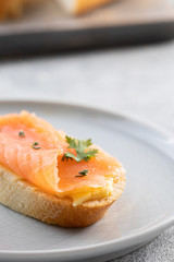 Bruschetta with smoked salmon and butter on concrete background. Delicious snack or appetizer.Close up