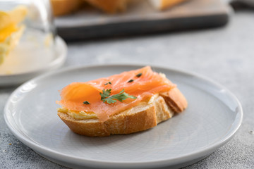 Bruschetta with smoked salmon and butter on concrete background. Delicious snack or appetizer.Close up