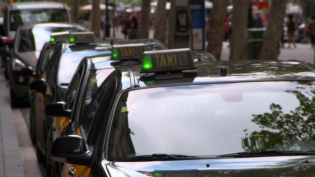 Lockdown shot of taxis parked in row on street in city - Barcelona, Spain