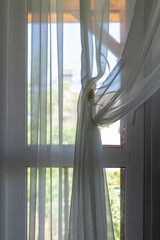 View of a wide window with curtains during a sunset.