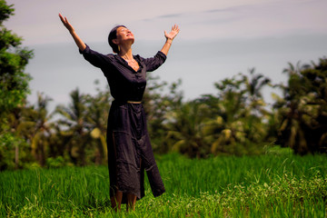 outdoors yoga and meditation at rice field - attractive and happy middle aged Asian Korean woman enjoying yoga and relaxation in connection with the nature