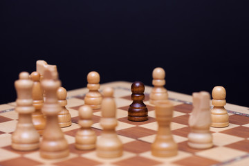 Chess, a lot of chess pieces on the Board. The white pieces surrounded the black pawn.