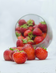 Fresh and juicy strawberries in glass on white background